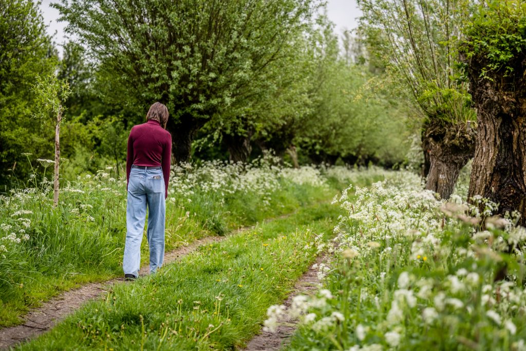 Een jonge vrouw loopt eenzaam en verdrietig door de natuur